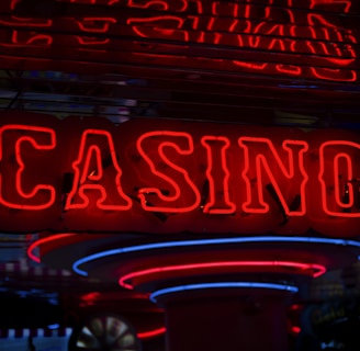 Neon lights display the word 'CASINO' in bright red, standing out against a dark background. The vibrant glow reflects a lively and bustling atmosphere.